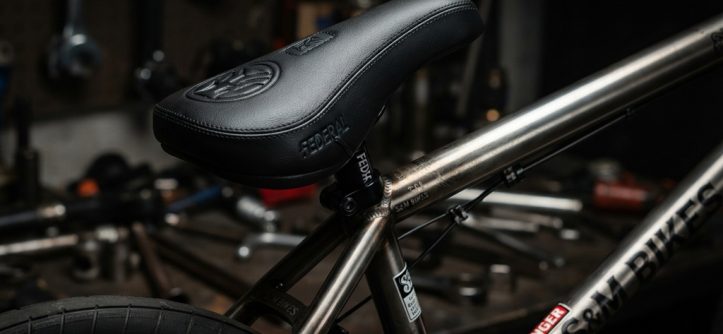 Close-up of a black padded BMX seat on a custom bike frame.